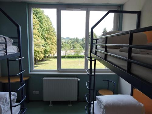 a dorm room with bunk beds and a window at Auberge de Jeunesse de Mulhouse in Mulhouse