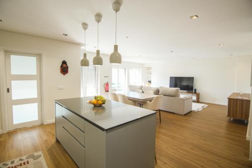 a kitchen and living room with a table and a couch at Yana Luxury Home in Queluz