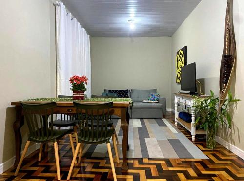 una sala de estar con una mesa, sillas y un sofá en Casa da Vila 2 dormitorios - Centro de Floripa, en Florianópolis