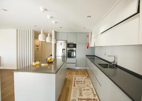 a kitchen with white cabinets and a counter top at Yana Luxury Home in Queluz