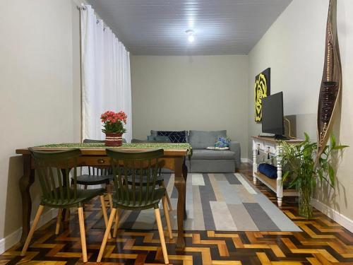 Una sala de estar con una mesa y sillas de madera. en Casa da Vila 2 dormitorios - Centro de Floripa, en Florianópolis