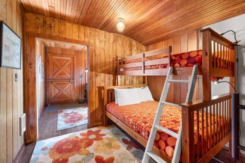 Un dormitorio con una litera y una escalera. en Historic Oceanside Cabin with Peek-a-boo views dog friendly, en Oceanside