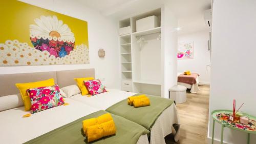 a bedroom with two beds and a table at Apartamentos La CárcaVa in Carcaboso