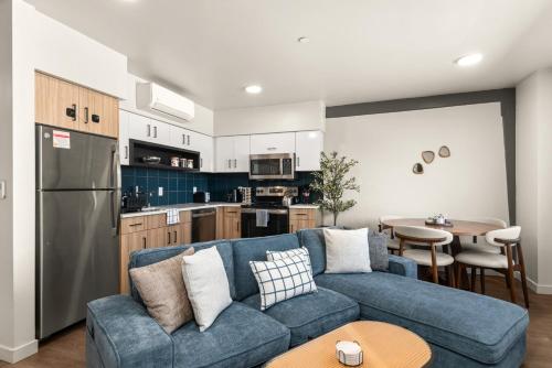 Una sala de estar con un sofá azul y una cocina. en 2BR Cozy Apartment in DT, en Spokane
