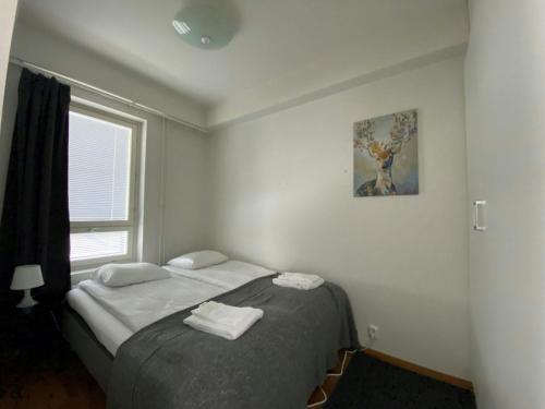 a bedroom with a bed with two towels on it at Convenient Apartment for 2 with Sauna in Kemi