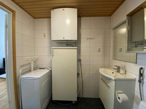 a small white bathroom with a sink and a washer at Convenient Apartment for 2 with Sauna in Kemi