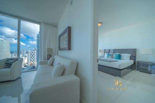 a living room with a white couch and a bed at GORGEOUS VIEWS Luxury Miami Brickell Pool Gym Spa in Miami