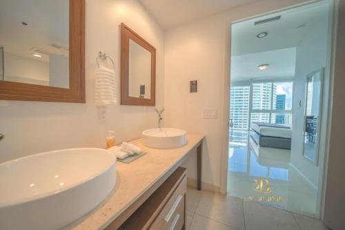 a bathroom with two sinks and a glass shower at GORGEOUS VIEWS Luxury Miami Brickell Pool Gym Spa in Miami