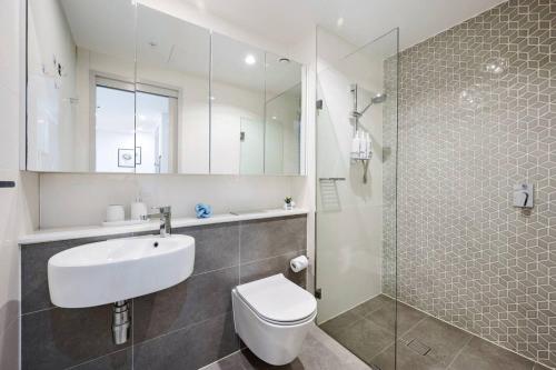 a bathroom with a sink and a toilet and a shower at Prime Mascot 2BR Pool Gym Sauna Access in Sydney