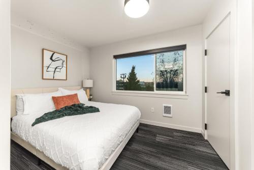 ein Schlafzimmer mit einem Bett und einem Fenster in der Unterkunft Downtown Luxury Stay 2BR in Spokane