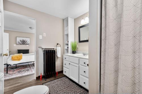 a bathroom with a toilet and a sink and a mirror at Roomy Central Hub, Games, Fire Pit & Downtown Fun in Oshkosh