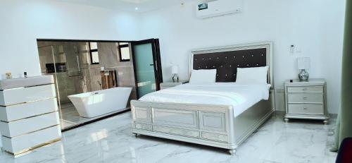 a bedroom with a bed and a tub and a sink at Canvas Luxury Villas in Lusaka