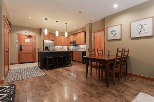 a kitchen with a wooden table and a dining room at Slalom Creek 2 Bedroom & Den in Rossland