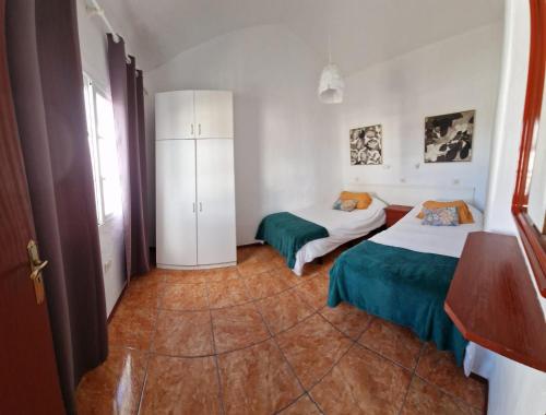 a room with two beds and a white cabinet at Viviendas Casa Abuela in El Paso