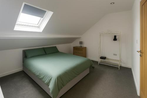 a bedroom with a green bed with a window at LT Duplex - 1 Bedroom Apartment in Leicester