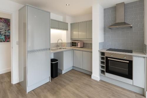 a kitchen with white cabinets and a stove at LT Duplex - 1 Bedroom Apartment in Leicester