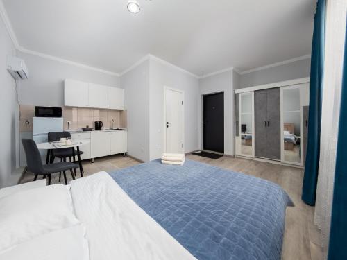 アルマトイにあるZhetysu Apartment on Sayahatの大きなベッドとキッチンのある寝室