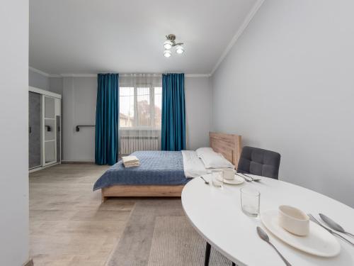 アルマトイにあるZhetysu Apartment on Sayahatのベッドルーム1室(ベッド1台、白いテーブル付)