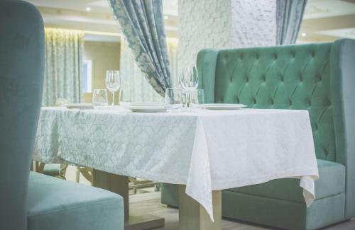 a dining room table with a white tablecloth and wine glasses at Bristol Central Park Hotel in Chişinău