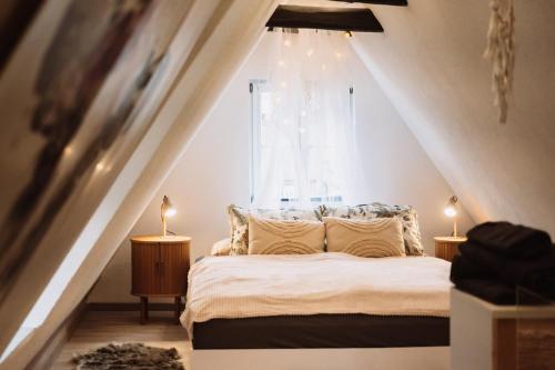 a bedroom with a bed with two lamps in front of a window at Ferienwohnung Ella in Dinkelsbühl