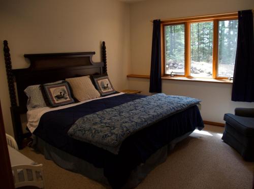 a bedroom with a large bed and a window at Fishtrap Lake Lodge 4400 sq feet 6 bedroom 3 bath in Boulder Junction