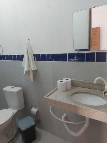 a bathroom with a toilet and a sink and a mirror at Pousada Paraíso das Dunas in Bitupitá