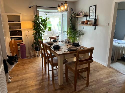 a dining room with a table with chairs and a cat at Wynstone Cottage, Speyside in Fochabers