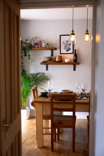 a dining room with a table and chairs with glasses at Wynstone Cottage, Speyside in Fochabers