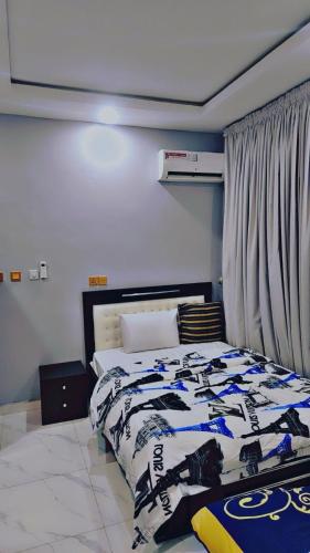 um quarto com uma cama com um cobertor preto e branco em A well-built 2 bedroom duplex em Lekki