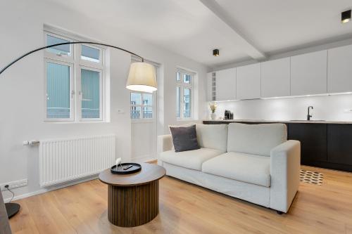 雷克雅未克Downtown Apartment with Parking的客厅里有一张白色的沙发和一张桌子