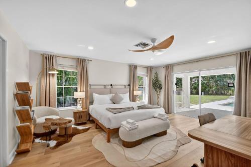 a white bedroom with a bed and a table and chairs at Palm Beach Polo & PGA Retreat - Pool & Luxe Comfort in Wellington