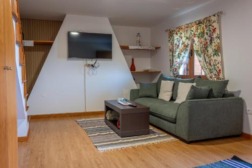a living room with a couch and a tv at Villa Fontes 7 in Ponta Delgada