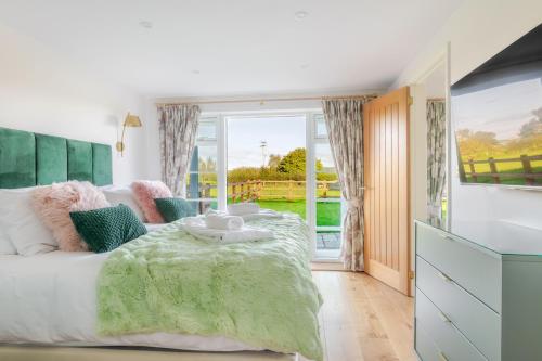 een slaapkamer met een bed en een groot raam bij Valley Farm Holiday Cottages in Axminster