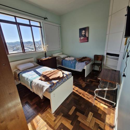 a bedroom with two beds and a window at Pousada Irmãs Franciscanas in Lages