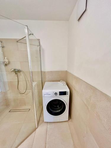 a washing machine in a bathroom with a shower at Spacious Modern Apartment with Free Parking in Gerasdorf bei Wien