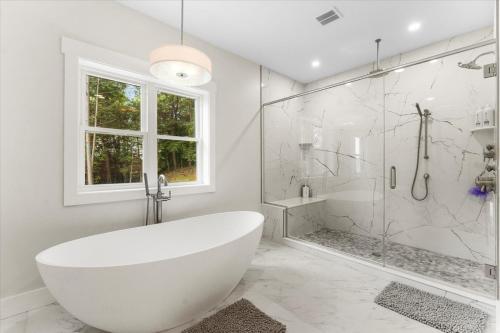Un baño blanco con bañera y ducha. en Eagle's Nest at Bolton Landing, en Bolton Landing