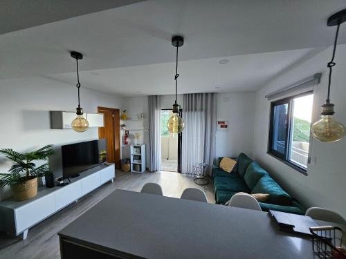 a living room with a green couch and a table at São Cristóvão AL in Boaventura