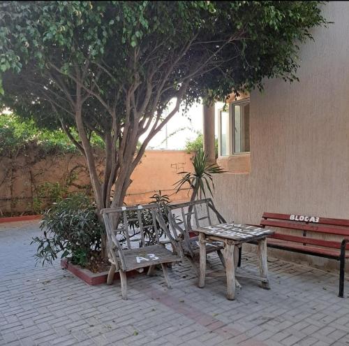 two benches and a table next to a tree at Appartement Casa in Essaouira