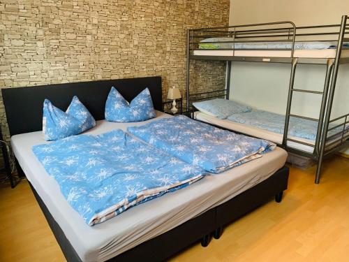 1 Schlafzimmer mit 2 Etagenbetten mit blauen Kissen in der Unterkunft Moderne Ferienwohnung - Top Lage nahe Skigebiet & Wanderwegen in Sankt Andreasberg