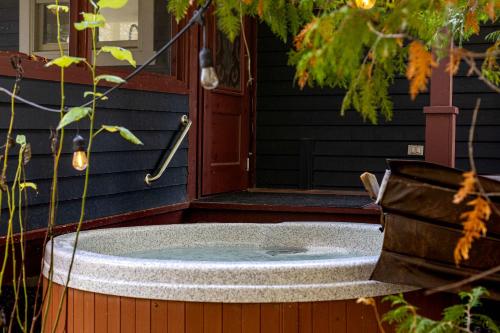 プティット・リヴィエール・サン・フランソワにあるBeau Lieu - River View - Spa And Pool Tableの家の外に座ってジャグジータブ