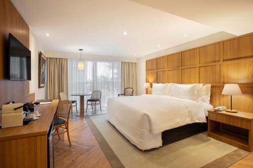 a hotel room with a large bed and a desk at Windsor Plaza Brasilia in Brasilia