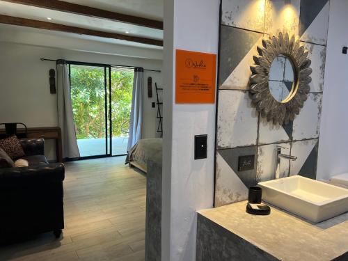 a bathroom with a sink and a clock on a wall at Villa Noelia in Saboga