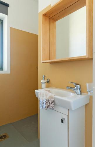 a bathroom with a sink and a mirror at Sea & Stone Villas in Koundouros