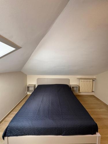 a bedroom with a blue bed in a attic at La casa i due cedri in Cuneo
