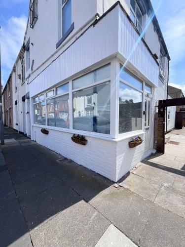 a white building with large windows on a street at Lansdowne Apartments in Hartlepool