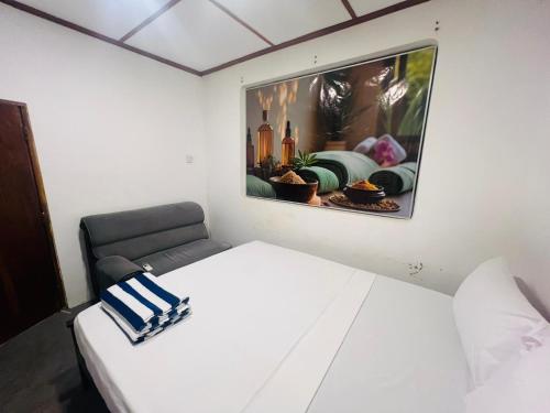 um quarto com uma cama branca e uma pintura na parede em Sun and Moon spa em Tangalle