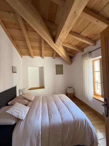 a bedroom with a large bed with wooden ceilings at la maison du soleil in Sigean