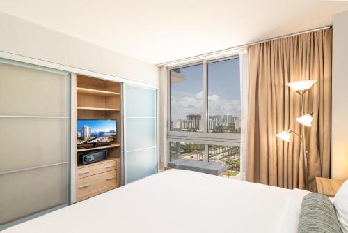 a bedroom with a large bed and a large window at Marenas LATERAL ocean view daily refresh not included Fees collected at arrival in Sunny Isles Beach