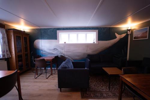 a living room with a whale mural on the wall at 1908 Hostel by Tröll in Vík