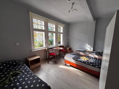 a room with two beds and a table and a window at Dom gościnny przy Promenadzie in Świnoujście